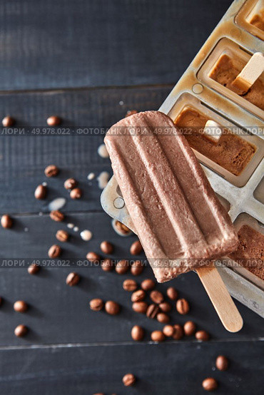 Homemade chocolate ice cream in plastic molds over wooden dark background, top view. Homemade prepare concept. Classic popsicle mold set freezer for homemade chocolate ice lolly in summer over wooden dark background, top view. Стоковое фото, агентство Ingram Publishing / Фотобанк Лори