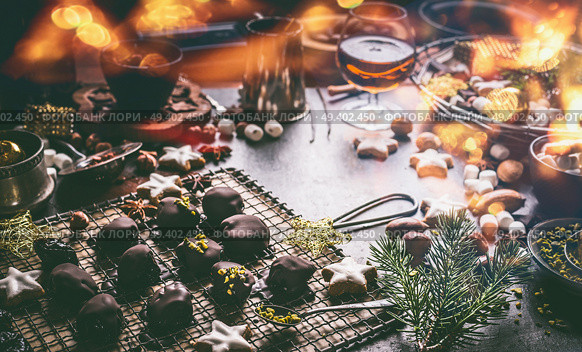 Homemade chocolate praline on dark table with nuts, marshmallows and cinnamon star Christmas cookies. Home holidays cuisine and sweet gifts making. Christmas food. Cozy festive homely atmosphere. Стоковое фото, агентство Ingram Publishing / Фотобанк Лори