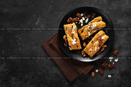 Homemade chocolate puff pastry braided strudel, pie with pecan nuts and almond, top view. Стоковое фото, агентство Ingram Publishing / Фотобанк Лори