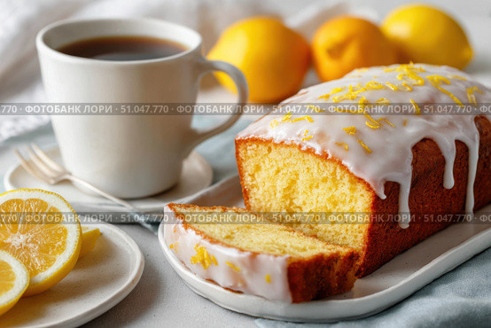 Homemade lemon drizzle cake with icing. Classic lemon pound cake with citrus glaze and zest. Whole loaf, side view, close up. Fresh homemade baked dessert with lemon slices. Blurred tea set background. Стоковое AI-изображение, AI-художник Марина Демидюк / Фотобанк Лори