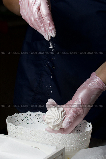 Homemade zephyr. White tray with marshmallows. A woman sprinkles marshmallows with dextrose. Стоковое фото, фотограф Vadzim Yakubovich / Фотобанк Лори