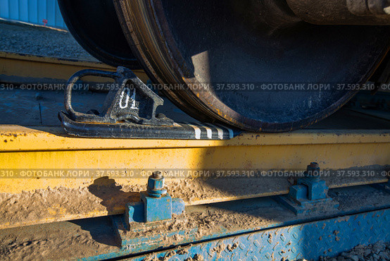 Hopper car railroad terminal. Phosphate fertilizers plant. Wagon wheel with brake shoe Close-up. Yellow clay dirt on rail. Стоковое фото, фотограф Alexey Rezvykh / Фотобанк Лори