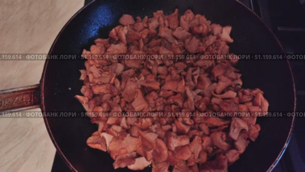 Hot mushroom dish – chanterelles fried with onions in oil. A fragrant dish of fried chanterelles and onions in a frying pan. A close-up of fried chanterelles is a simple and delicious meal. Стоковое видео, видеограф Андрей Жигальцов / Фотобанк Лори