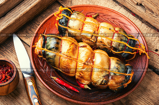 Hot smoked mackerel roll.Delicious smoked fish on plate. Smoked mackerel on wooden background. Стоковое фото, агентство Ingram Publishing / Фотобанк Лори