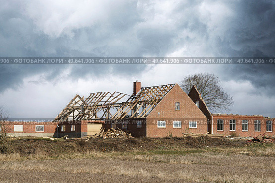 House damaged by a storm with roof destroyed under a cloudy sky. Стоковое фото, агентство Ingram Publishing / Фотобанк Лори
