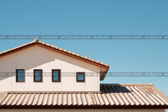 House Exterior. Roof Window. Second floor among blue sky. Mansard attic. Newly build houses. Gable roof with skylight, asphalt roofing, shingles. Residential Home. Vinyl Siding. Polymeric roof-tiles. Стоковое AI-изображение, AI-художник Марина Демидюк / Фотобанк Лори