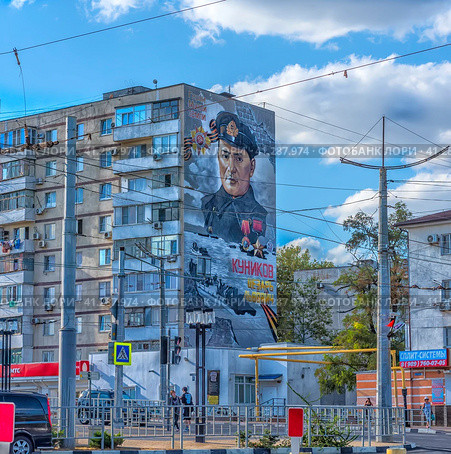 House with graffiti on the facade depicting Tsezar Lvovich Kunikov - Soviet officer, commander of the landing detachment that captured the Malaya Zemlya bridgehead, Hero of the Soviet Union in the hero city of Novorossiysk (2023) Редакционное фото, фотограф Анна Кривицкая / Фотобанк Лори