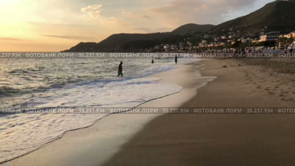 Hyperlapse of sandy Kleopatra beach with people enjoying sea and sun. It is urban sandy beach is close to mountain with the Alanya castle. Turkey (2021 год). Редакционное видео, видеограф Кекяляйнен Андрей / Фотобанк Лори