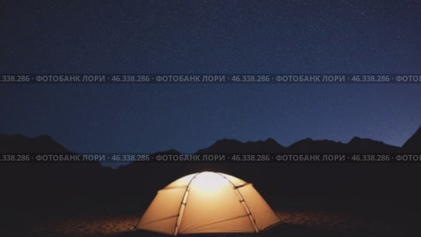 Illuminated tent under starry night sky in mountains. Стоковое видео, видеограф Данил Руденко / Фотобанк Лори