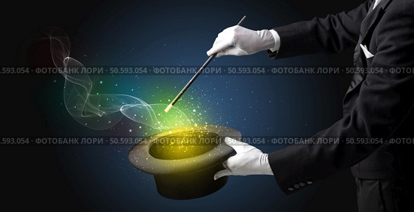 Illusionist hand starts to conjure with white glove and magic wand. Стоковое фото, агентство Ingram Publishing / Фотобанк Лори