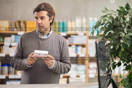 In drug store, man examine paracetamol antipyretic pills. Стоковое фото, фотограф Яков Филимонов / Фотобанк Лори