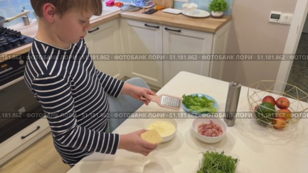 In the kitchen, a cute guy is cooking up a delicious carbonara sauce to go with his pasta. Стоковое видео, видеограф Ирина Старикова / Фотобанк Лори