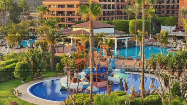 Indulge in a Luxury Resort featuring Multiple Pools and Exciting Water Slides in a Tropical Paradise. Стоковое видео, видеограф Vladimir Vintonjak / Фотобанк Лори