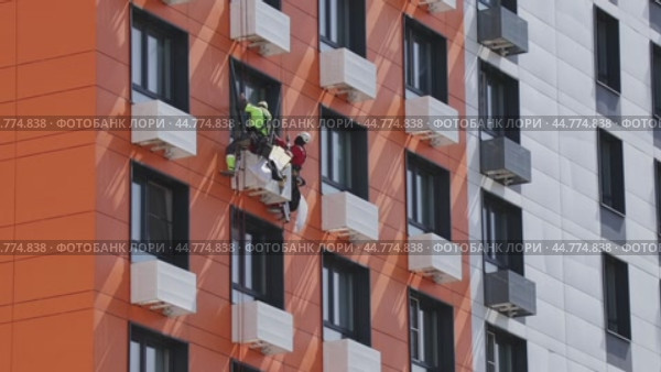 Industrial mountaineers working at height install window panels. High rise work. Стоковое видео, видеограф Светлана Ельцова / Фотобанк Лори