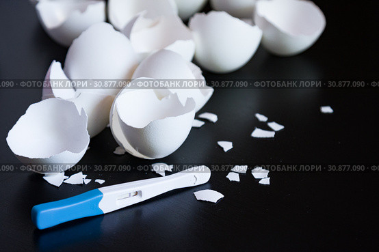 Infertility. Negative pregnancy test and eggshell on black. Стоковое фото, фотограф Papoyan Irina / Фотобанк Лори