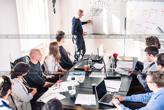 Informal IT business startup company meeting. Team leader discussing and brainstorming new project and ideas with colleagues. Startup business and entrepreneurship concept. Стоковое фото, фотограф Matej Kastelic / Фотобанк Лори