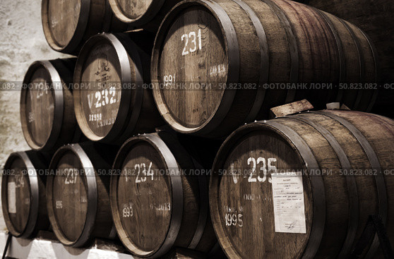 Inkerman winery interior with stacked oak barrels with wine (2018 год). Редакционное фото, фотограф EugeneSergeev / Фотобанк Лори