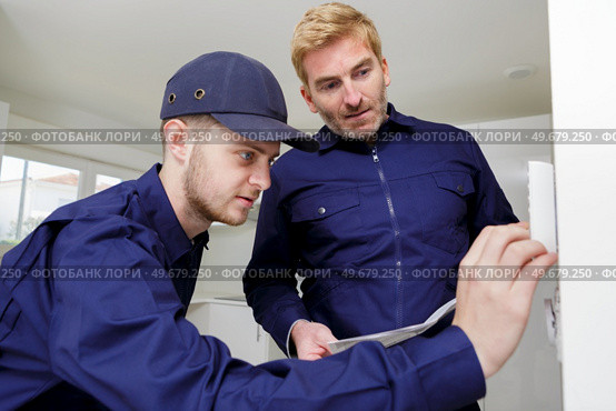 installing a programmable room thermostat. Стоковое фото, агентство Ingram Publishing / Фотобанк Лори