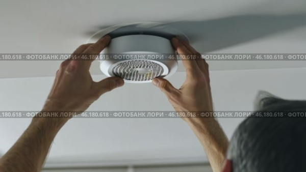 Installing a smoke detector for enhanced home safety and protection. Стоковое видео, видеограф Zakharova Natasha / Фотобанк Лори