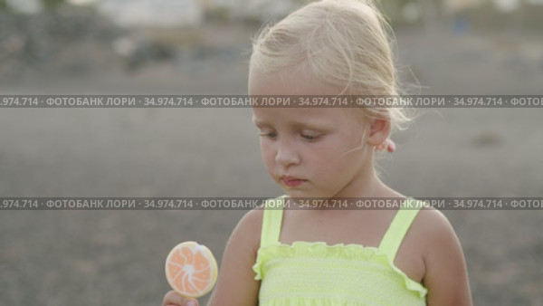 It is hard to bite the lollipop, but she did it. Стоковое видео, видеограф Данил Руденко / Фотобанк Лори