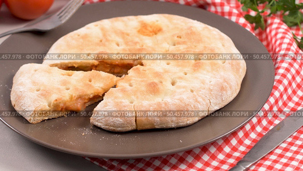 Italian food, pizza calzone with tomato, spinach and cheese on wooden background. Стоковое фото, агентство Ingram Publishing / Фотобанк Лори