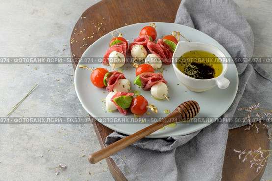 Italian style appetizer, antipasto skewer or caprese on a stick with basil, salami, mozarella and tomatoes. Стоковое фото, агентство Ingram Publishing / Фотобанк Лори