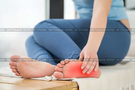 Joint diseases, hallux valgus, plantar fasciitis, heel spur, woman's leg hurts, pain in the foot, massage of female feet at home. Стоковое фото, фотограф Станислав Тарко / Фотобанк Лори