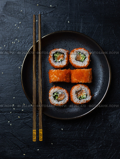 Juicy californium roll on a black plate with chopsticks. Стоковое фото, фотограф Анна Никитина / Фотобанк Лори