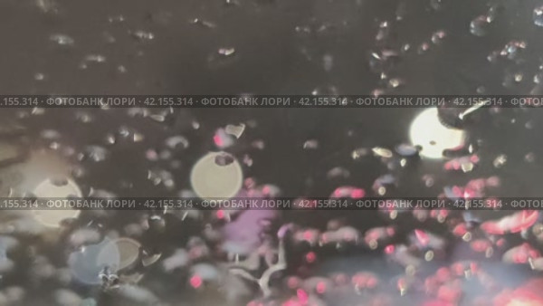 Капли дождя на стекле. Осенний поздний темный вечер, за окном идет дождь. Капли дождя падают на прозрачное стекло и стекают по нему. За окном светятся огни, проезжают машины. Стоковое видео, видеограф Andrew_Swarga / Фотобанк Лори
