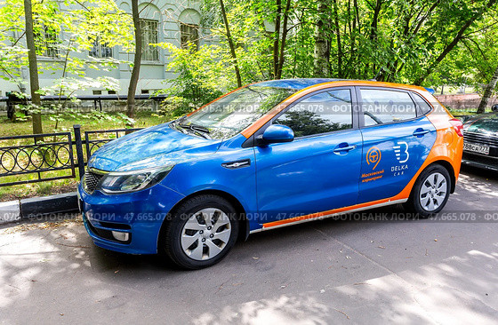 Каршеринговый автомобиль Belka Kia Rio хэтчбек припаркован на городской улице в летний день (2019 год). Редакционное фото, фотограф FotograFF / Фотобанк Лори