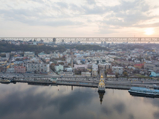 Kiev, Ukraine: 15 April, 2018 - Church of St. Nicholas the Wonderworker on Dnieper River on sunset, photography from drone City landscape with evening sky and clouds and view of Podol in city of Kiev, Ukraine. Kiev, Ukraine: 15 April, 2018 - Church of St. Nicholas the Wonderworker on Dnieper River on sunset, photography from drone. Редакционное фото, агентство Ingram Publishing / Фотобанк Лори