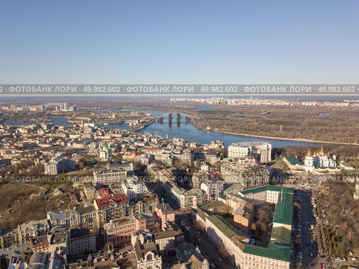 Kiev, Ukraine - April 7, 2018: Trukhanov Island, the Dnieper River and the hem district with the Vladimir Church and St. Andrew’s Church on a blue sky background on a sunny day. Drone photography. Kiev, Ukraine - April 7, 2018: Landscape view of the old district of Podol with the Vladimir Church and St. Andrew’s Church against the blue sky. Редакционное фото, агентство Ingram Publishing / Фотобанк Лори