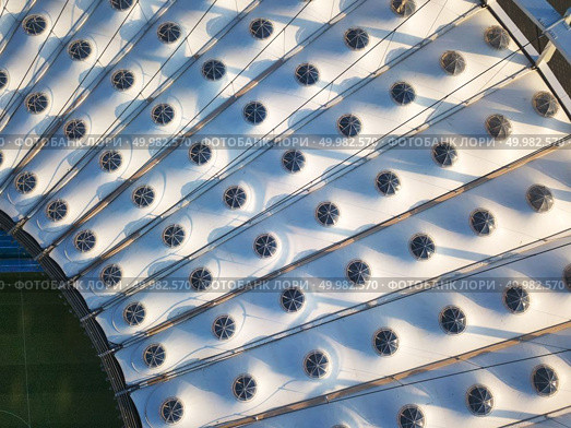 KIEV, UKRAINE - July 19, 2018. Aerial view from drone of the stadium cover structure - NSC Olimpiysky. Elements of the stadium construction. Abstract architecture photo.. KYIV, UKRAINE - July 19, 2018. NSC Olimpiysky. The construction of the stadium roof of National Sports Complex Olympic. Редакционное фото, агентство Ingram Publishing / Фотобанк Лори