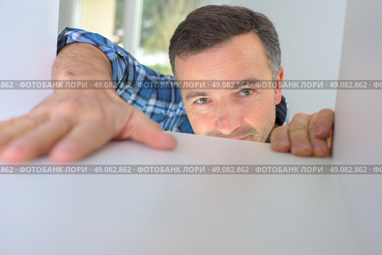 Kitchen fitter installing a cupboard. Стоковое фото, агентство Ingram Publishing / Фотобанк Лори