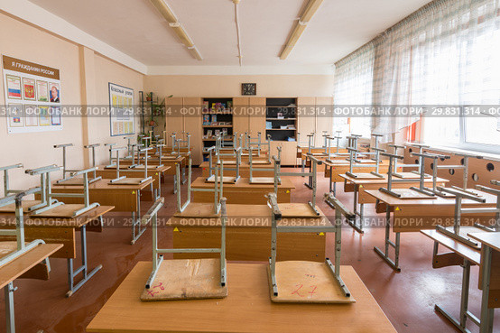 Класс в школе после занятий, стулья сложены на партах (2019 год). Редакционное фото, фотограф Иванов Алексей / Фотобанк Лори