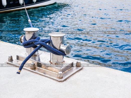 Knecht anchorage on a marina with a blue rope tied. Copy space, close up. Стоковое фото, фотограф Александр Довянский / Фотобанк Лори