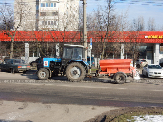 Колесный трактор с прицепом для посыпки дорог противогололедными реагентами едет по Уссурийской улице. Район Гольяново. Город Москва (2020 год). Редакционное фото, фотограф lana1501 / Фотобанк Лори