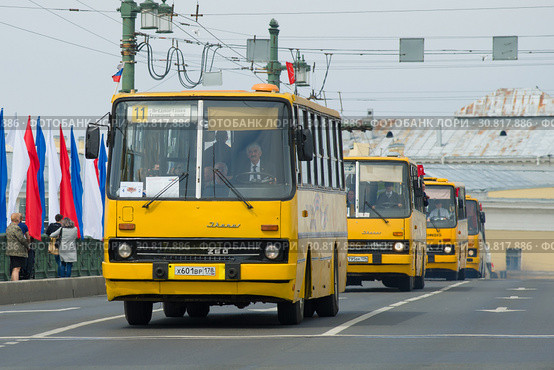 Колонна желтых венгерских автобусов "Икарус" на Дворцовом мосту. Фрагмент парада ретротранспорта в День города. Санкт-Петербург (2019 год). Редакционное фото, фотограф Виктор Карасев / Фотобанк Лори