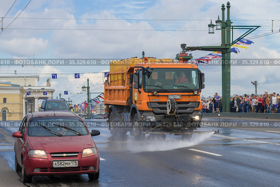 Коммунальный автомобиль "Мерседес-Бенц Актрос" поливает Дворцовый мост июльским днем. Санкт-Петербург, Россия (2017 год). Редакционное фото, фотограф Виктор Карасев / Фотобанк Лори
