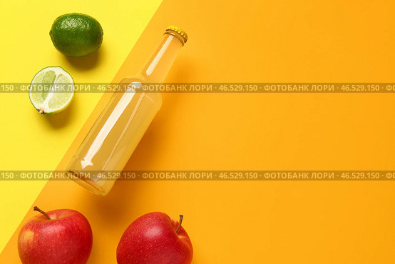 Композиция с бутылкой вкусного газированного напитка, яблоками и лаймом на цветном фоне. Стоковое фото, фотограф Pixel_shot / Фотобанк Лори