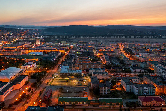 Красивый утренний аэрофотоснимок северного города. Вид сверху на здания и пустые улицы. Рассвет. Вдалеке сопки. Город Магадан, Магаданская область, Дальний Восток России. Стоковое фото, фотограф Андрей Степанов / Фотобанк Лори