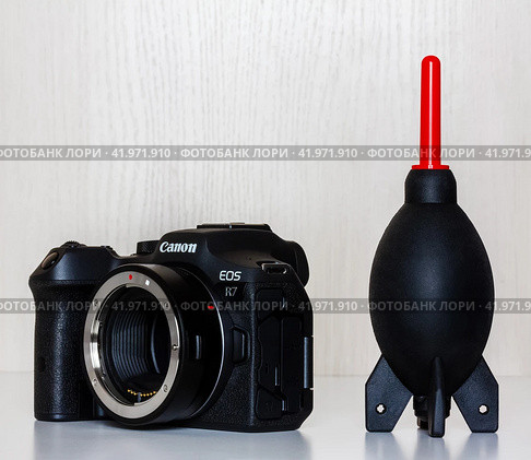 Krasnodar, Russia - December 28, 2023: mirrorless camera Canon eos r7 with adapter for lenses with EF, EF-S mount and rubber Blower for removal of dust from the camera and optics. Редакционное фото, фотограф Андрей С / Фотобанк Лори