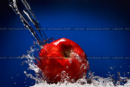Красное яблоко с всплеском воды на синем фоне. Стоковое фото, фотограф Ярослав Данильченко / Фотобанк Лори