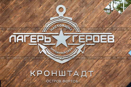 Kronshtadt, Russia-circa Sep, 2020: Logo and emblem in Russian of the Camp of Real Heroes on gates. It is an all-Russian project of patriotic education of youth. Редакционное фото, фотограф Кекяляйнен Андрей / Фотобанк Лори