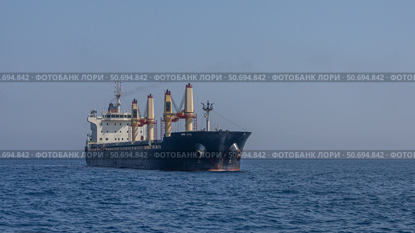 Крупное морское судно перевозит грузы в открытом море. Плавание крупных судов. Крупное грузовое судно в море. Из трубы морского судна выходит дым. Стоковое фото, фотограф Эдуард Белкин / Фотобанк Лори