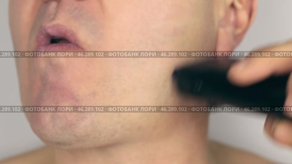 Крупным планом бреется мужчина, бреется электробритвой. Стоковое видео, видеограф Александр Собко / Фотобанк Лори