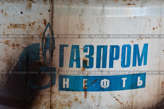 Крупным планом старая металлическая бочка с названием компании Газпромнефть, Россия (2024 год). Редакционное фото, фотограф Николай Винокуров / Фотобанк Лори