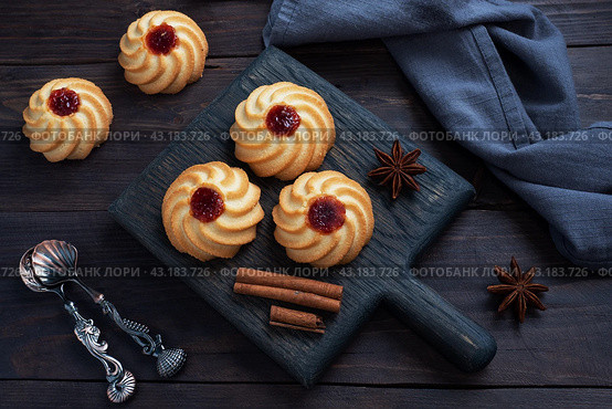 Kurabye shortbread cookies with berry jam in a black plate. Delicious dessert, dark wooden background with copy space. Стоковое фото, фотограф Глущенко Елена / Фотобанк Лори