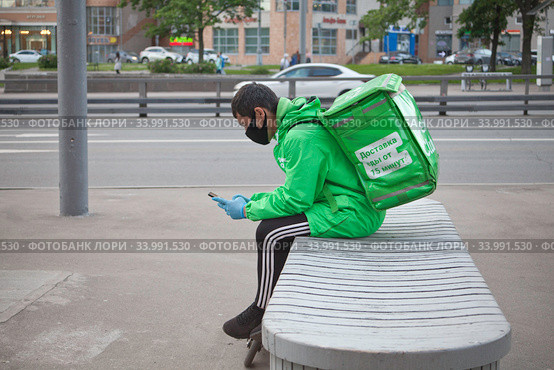 Курьер сервиса доставки еды Delivery Club на улице в Москве (2020 год). Редакционное фото, фотограф Victoria Demidova / Фотобанк Лори