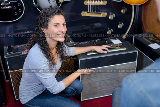 Lady showing amplifier to customer. Стоковое фото, агентство Ingram Publishing / Фотобанк Лори